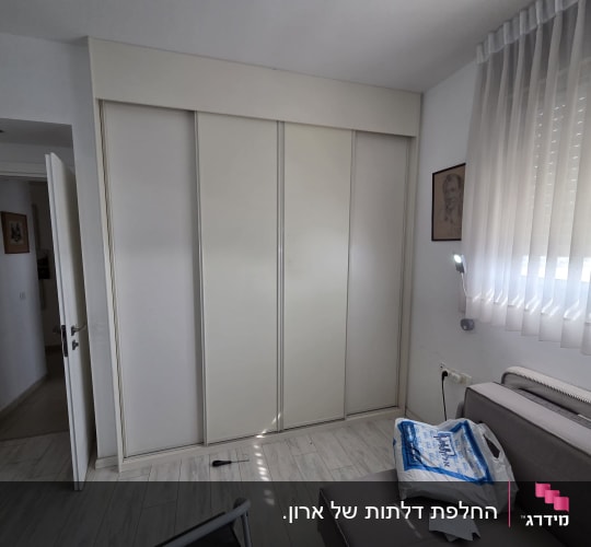ארון בגדים לבן עם דלתות הזזה בחדר שינה